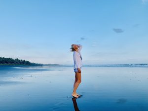 Kerstin Hardt steht am Strand und strahlt die Vitalität aus, die von Hybrid Training kommt: Die beste Bewegung für Gesundheit